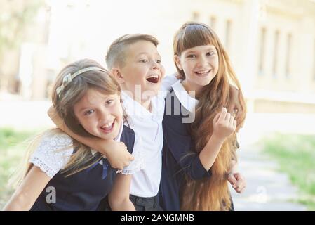 Portrait von begeistert Grundschüler auf dem Spielfeld in den Pausen. Glückliche Kinder Mädchen und jungen Freund Student an der Volksschule. Stockfoto