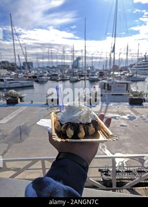 Mann, Belgischen Waffeln mit Schlagsahne mit Marina Hintergrund Stockfoto