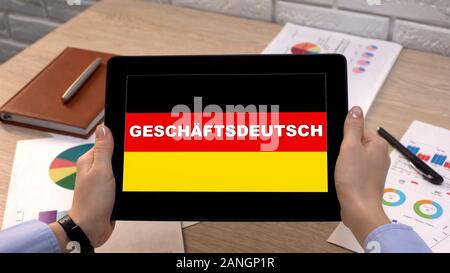 Deutsch Anwendung gegen die Flagge auf Tablet in weibliche Hände, Tutorial Stockfoto