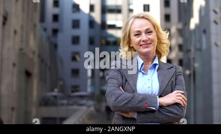 Freundliche ältere Business Frau suchen Kamera außerhalb der Gebäude, Job Stockfoto