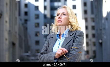 Zögern Frau in Anzug denken der unternehmerischen Entscheidung, Brillen Holding Stockfoto
