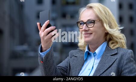 Gerne schöne Dame in kleinen Spiegel suchen, mit Reflexion zufrieden Stockfoto