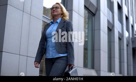 Happy lady Boss in der Klage zu Fuß Bürogebäude, zufriedene Unternehmen Manager Stockfoto