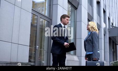 Junge Unternehmen Mitarbeiter sprechen mit strengen Chefin außerhalb der Gebäude Stockfoto