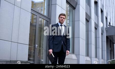 Besorgt, Office Manager stehen im Freien halten Dokumente, unzufriedener Arbeiter Stockfoto