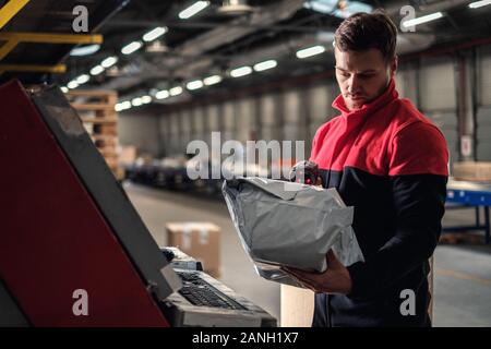 Kurier holt Paket auf einem Lager Stockfoto