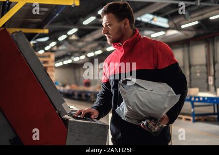 Kurier holt Paket auf einem Lager Stockfoto