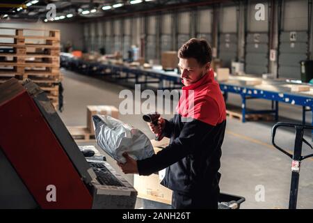Kurier holt Paket auf einem Lager Stockfoto