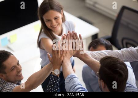 Nahaufnahme von lächelnden jungen Büro Kollegen hoch fünf für gemeinsames Ziel oder Erfolg motiviert, begeistert Mitarbeiter melden Sie Hände in Teambuilding eingerückt Stockfoto