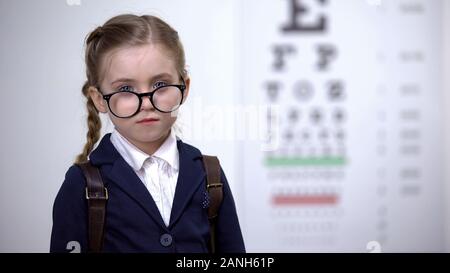 Süßes Schulmädchen über Gläser, schwere Kind mit guten Anblick, Korrektur Stockfoto