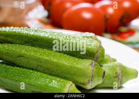 Frische grüne Okran- oder Damenfinger. Nahaufnahme mit Wassertröpfchen. Stockfoto