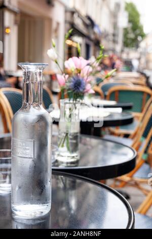 Blumen auf den Tischen eines Pariser Cafés in Paris, Frankreich in der Rue de Buci. Stockfoto