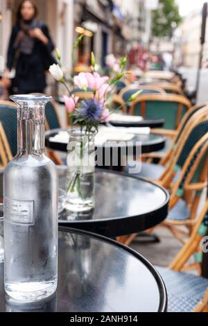 Blumen auf den Tischen eines Pariser Cafés in Paris, Frankreich in der Rue de Buci. Stockfoto
