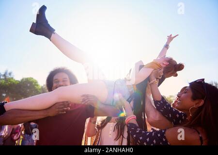 Erregte Frau Crowdsurfing beim Musikfestival Stockfoto