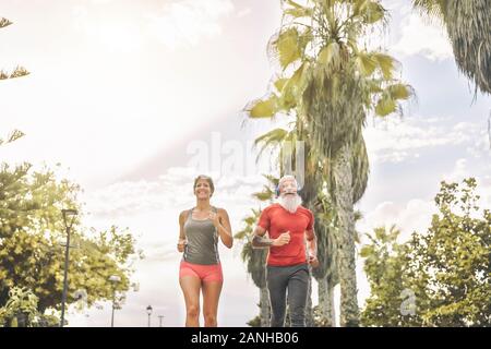 Passen Freunde zusammen Joggen im Park Outdoor - Sportliche reife Menschen tun Training außerhalb der laufenden Übungen Stockfoto