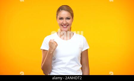 Hübsche Frau im weißen T-Shirt, ja Geste, Leistung, Erfolg Stockfoto