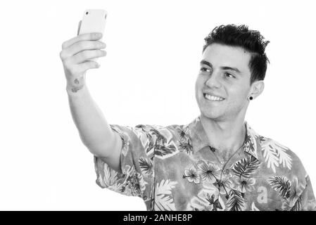 Studio shot Der glückliche junge Mann lächelnd während der Einnahme von selfie Bild mit Handy Stockfoto