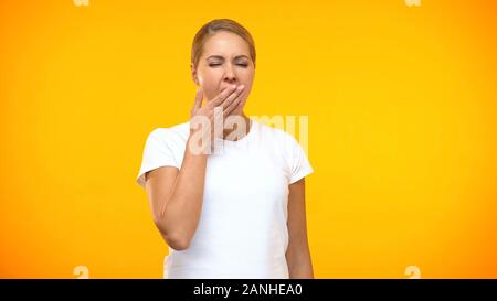 Schläfrige Frau im weißen T-Shirt gähnen, Langeweile, faule Arbeitnehmer, Müdigkeit Stockfoto