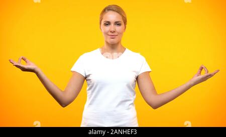Kaukasische Frau im weißen T-Shirt mit Yoga, Entspannungstechniken, Harmonie Stockfoto