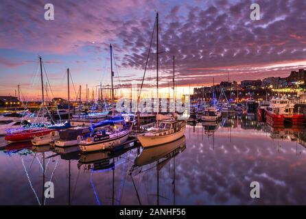 Die Boote und Jachten leuchten mit weihnachtslichtern in der Ramsgate Royal Harbour Marina in Kent. Stockfoto