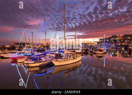 Die Boote und Jachten leuchten mit weihnachtslichtern in der Ramsgate Royal Harbour Marina in Kent. Stockfoto