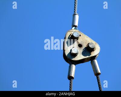 Kran Stahl Kabel Schlinge mit Kabel angeschlossen und die Spaltung in zwei Richtungen. abstrakte Sicht von Baumaschinen mit blauem Himmel Hintergrund Stockfoto