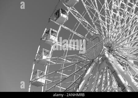 Großes Riesenrad dreht sich auf grauem Hintergrund. Die Menschen sind Reiten weel und genießen Sie den Panoramablick auf die Stadt. Niedrigen Winkel anzeigen, kopieren und Makrofotografie Stockfoto