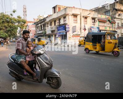 Gefährliches fahren. Eine indische Straße Szene mit einem Mann, der ein kleines Mädchen eine Fahrt auf dem Moped ohne Helm. Chennai, Tamil Nadu, Indien. Stockfoto