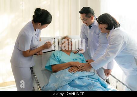 Asiatische medizinische Team von Ärzten untersucht und im Gespräch mit asiatischen ältere Frau patient, Gesundheit Menschen bemerken auf Zwischenablage im Krankenhaus. Ältere pat Stockfoto