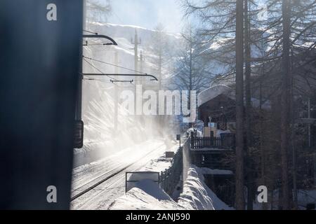 Zermatt Schweizer Bergbahn Pulverschnee in der Luft sonnigen Bäume Stockfoto