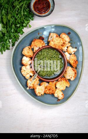 Veganes Essen mit orientalischen Aromen: Harissa Blumenkohl mit Corriander Pesto Stockfoto