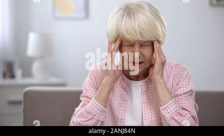 Ältere Frau massieren schmerzhafte Tempel, dass Schmerzmittel, Gesundheit Problem Stockfoto