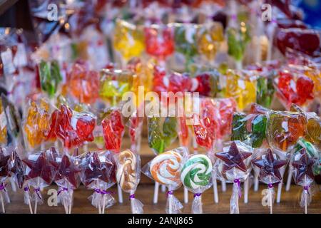 Viele verschiedene bunte Karamellbonbons an Weihnachten Messe verkauft. Bunte lollipops Verkauf im Supermarkt. Stockfoto