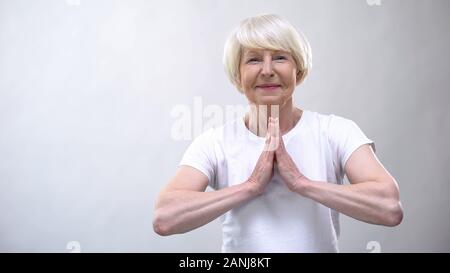 Friedliche ältere Frau in der Meditation in die Kamera lächeln, innere Balance Stockfoto