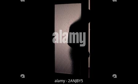 Dunkler Schatten der mit Kapuze Mann öffnung Glastür, Gefahr der Einbruch der dunkle Hintergrund Stockfoto