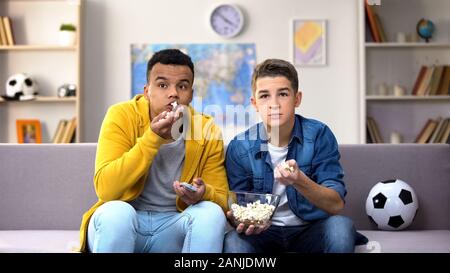 Emotionale jugendlich Freunde essen Pop Corn, Jubel für Favorit Fußball teem Stockfoto