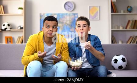 Multirassischen jugendlich Freunde mit Popcorn, Fußball Spiel im Fernsehen zu Hause Stockfoto