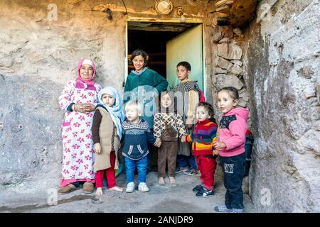 Aroumd, Marokko - Januar 7, 2020: Berber Großmutter kümmert sich um viele Kinder vor ihrem Haus Stockfoto