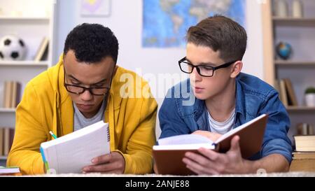 Schwarz und kaukasische Studenten schreiben Bericht für Lehre, Bildung Stockfoto