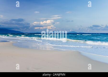 Schöne, leere tropischen weißen Sandstrand, kleine Wellen im Meer Hintergrund. Skyline mit blauem Himmel und weißen Wolken, Asien Stockfoto