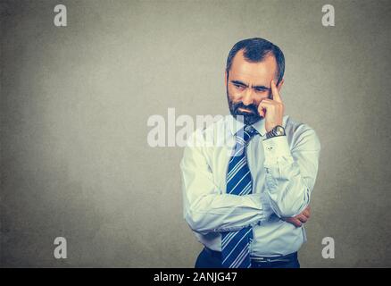 Closeup Portrait bärtigen erwachsenen Mann in stressigen Gedanken, denken, dass Migräne Kopfschmerzen. Gemischte Rasse bearded Modell isoliert auf grau Studi Stockfoto