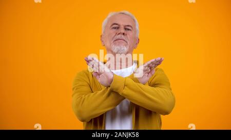 Alter Mann Kreuzung Hände unzufrieden, schlechter Service, STOP-Schild Geste Stockfoto