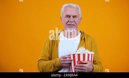 Lächelnd älterer Mann mit Pop Corn, spannender Film, Freizeitgestaltung Stockfoto