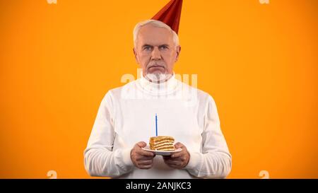 Einsame ältere männliche Holding Geburtstagskuchen, leider auf Kamera, Einsamkeit Stockfoto
