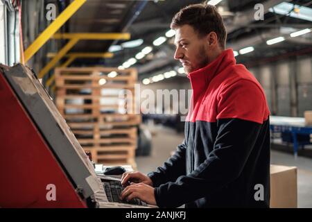 Kurier holt Paket auf einem Lager Stockfoto