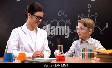 Chemie Lehrer lächelnd beobachten Schüler die Durchführung von Forschungen, die Lektion Stockfoto