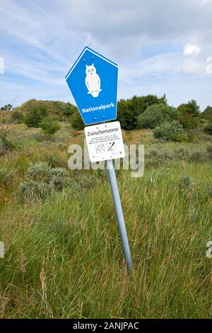 Gelehntes Metallschild mit einer bemalten weißen Eule, die auf ein Zwischengebiet im Nationalpark auf der Insel Borkum hinweist Stockfoto