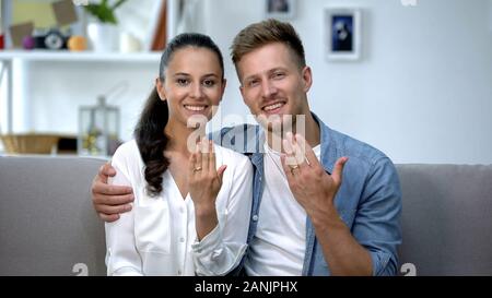 Freundliche Paar sitzt auf dem Sofa, die Hände mit Verlobungsringe, Liebe Stockfoto