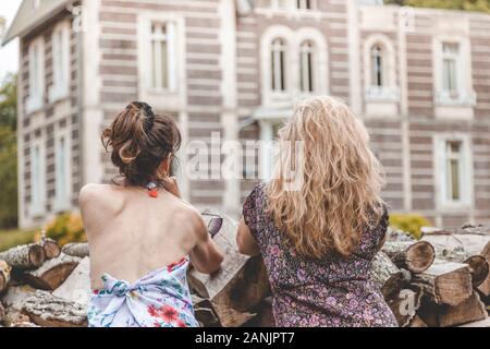 Paar Reifen freundlich Frauen im Urlaub gerade eine erstaunliche historische Gebäude von einem Woodpile. in der Natur Stockfoto