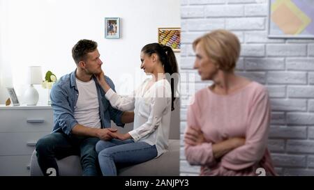 Unzufrieden Schwiegermutter aufpassen junges Paar zu Hause flirten, Eifersucht Stockfoto